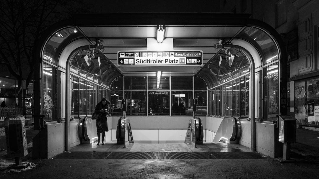 Eine Person verlässt die U-Bahn-Station 'Südtiroler Platz' in Wien. Schwarz-Weiß.